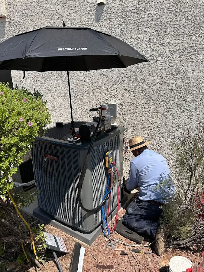 HVAC technician performing outdoor AC maintenance in Stow