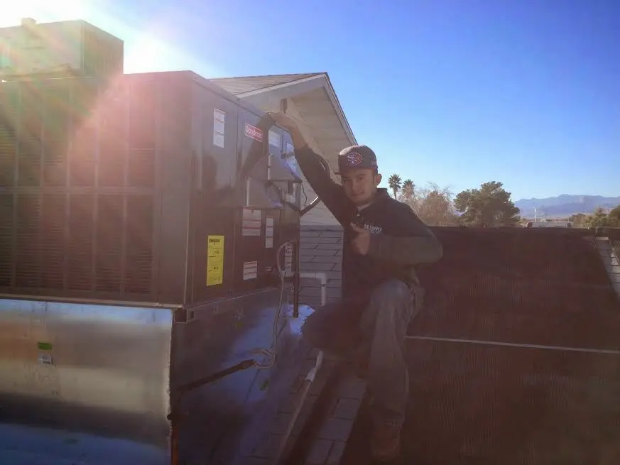 HVAC technician performing Air Duct Cleaning on a rooftop unit in Stow